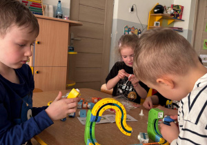 Grupa dzieci buduje konstrukcje z klocków