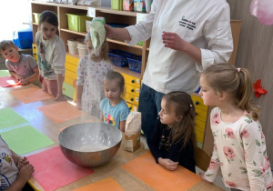 Piekarz wsypuje mąkę do miski