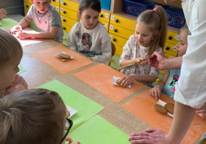 Dziewczynka smaruje ciastko kajmakiem