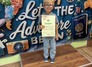 Chłopiec stoi z nagrodami po konkursie