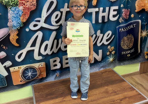 Chłopiec stoi z nagrodami po konkursie