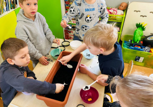 Dzieci przesypują ziemię