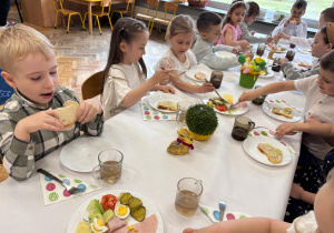 Dzieci jedzą wspólne śniadanie