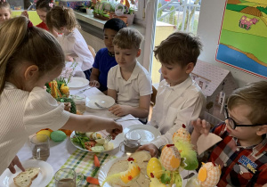 Dzieci jedzą wspólne śniadanie