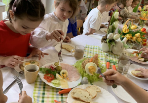 Dzieci jedzą wspólne śniadanie
