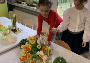 Dzieci dekorują stół wielkanocny