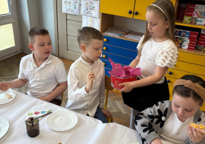 Dziewczynka wręcza dzieciom ciastka