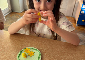 Dziewczynka lepi kurczaczka z plasteliny