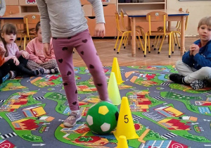 Dziewczynka toczy piłkę