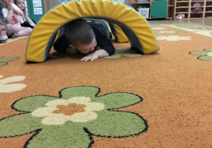 Chłpiec czołga się po dywanie