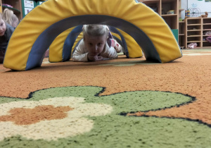 Dziewczynka czołga się po dywanie