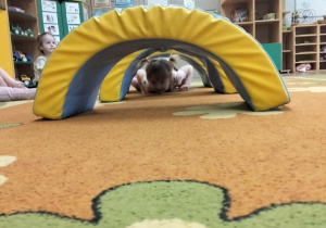 Dziewczynka czołga się po dywanie