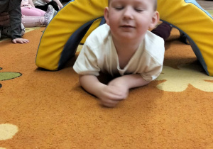 Chłopiec czołga się po dywanie