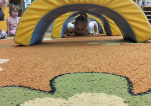 Dziewczynka czołga się po dywanie