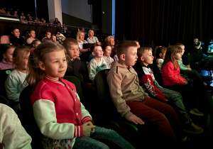 Dzieci oglądają z zaciekawieniem przedstawienie teatralne