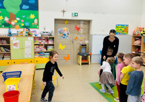 Dziewczynka segreguje piłkę w odpowiednim pojemniczku