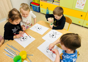 Dzieci wykonują pracę plastyczną- używając farb, słomek i pędzelków