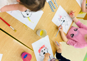 Dzieci wykonują pracę plastyczną- używając farb, słomek i pędzelków