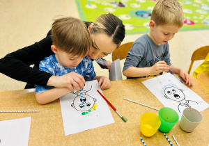 Dzieci wykonują pracę plastyczną- używając farb, słomek i pędzelków