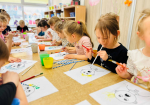 Dzieci wykonują pracę plastyczną- używając farb, słomek i pędzelków