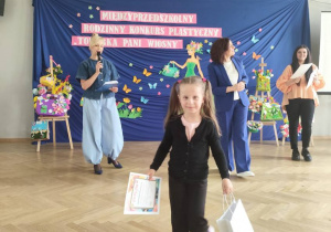 Dziewczynka odbiera nagrodę