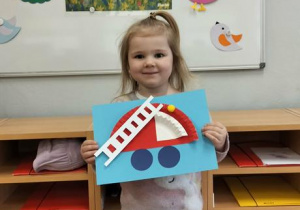 Dziewczynka ze swoją pracą plastyczną