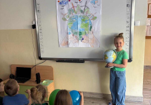 Dzieci pozują do zdjęcia z plakatem