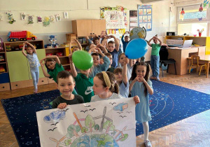 Dzieci pozują do zdjęcia z plakatem