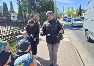 Dzieci wręczają flagi przechodniom