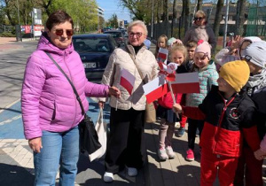 Dzieci wręczają flagi przechodniom