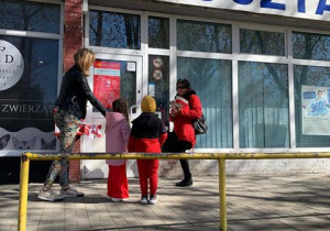 Dzieci wręczają flagi przechodniom