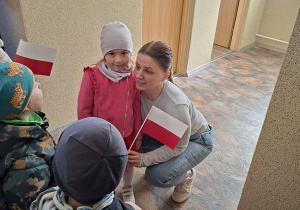 Dzieci przekazują chorągiewki pracownikom szkoły