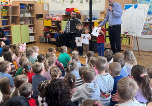 Dzieci stoją na środku sali z literami