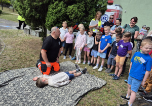 Dzieci oglądają pokaz pierwszej pomocy