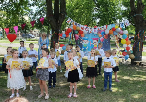 Dzieci śpiewają piosenkę trzymając książki
