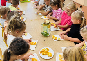 Dzieci przygotowują owoce do lemoniady