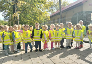 Maluszki pozują do zdjęcia przed przedszkolem