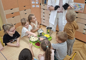 Odkrywcy wspólnie z panią intendentką przygotowują składniki do owocowych koktajli.