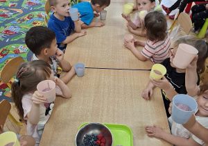 Odkrywcy z kubeczkami pełnymi owocowego koktajlu podczas wspólnej degustacji.
