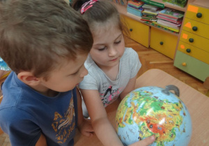 Dzieci szukają kontynetów na globusie