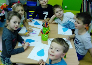 Dzieci tworzą pracę plastyczną "Wesołe kropelki"