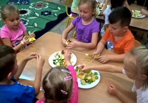 Przedszkolaki wykonują owocowe szaszłyki