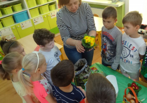 Nauczycielka sadzi z dziećmi kwiaty