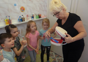 Nauczycielka pokazuje technikę mycia zębów
