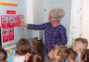 Nauczycielka pokazuje plansze prawidłowego mycia zębów