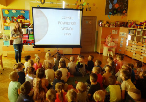 Nauczycielka opowiada dzieciom o zanieczyszczeniu powietrza