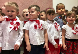 Dzieci wspólnie z uczniami w szkole śpiewają pieśń