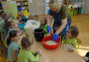 Dzieci przyglądają się kiszeniu kapusty