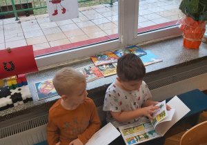 Chłopcy oglądają książki o Koziołku
