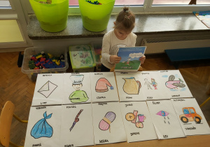 Dziewczynka pokazuje rysunki dzieci